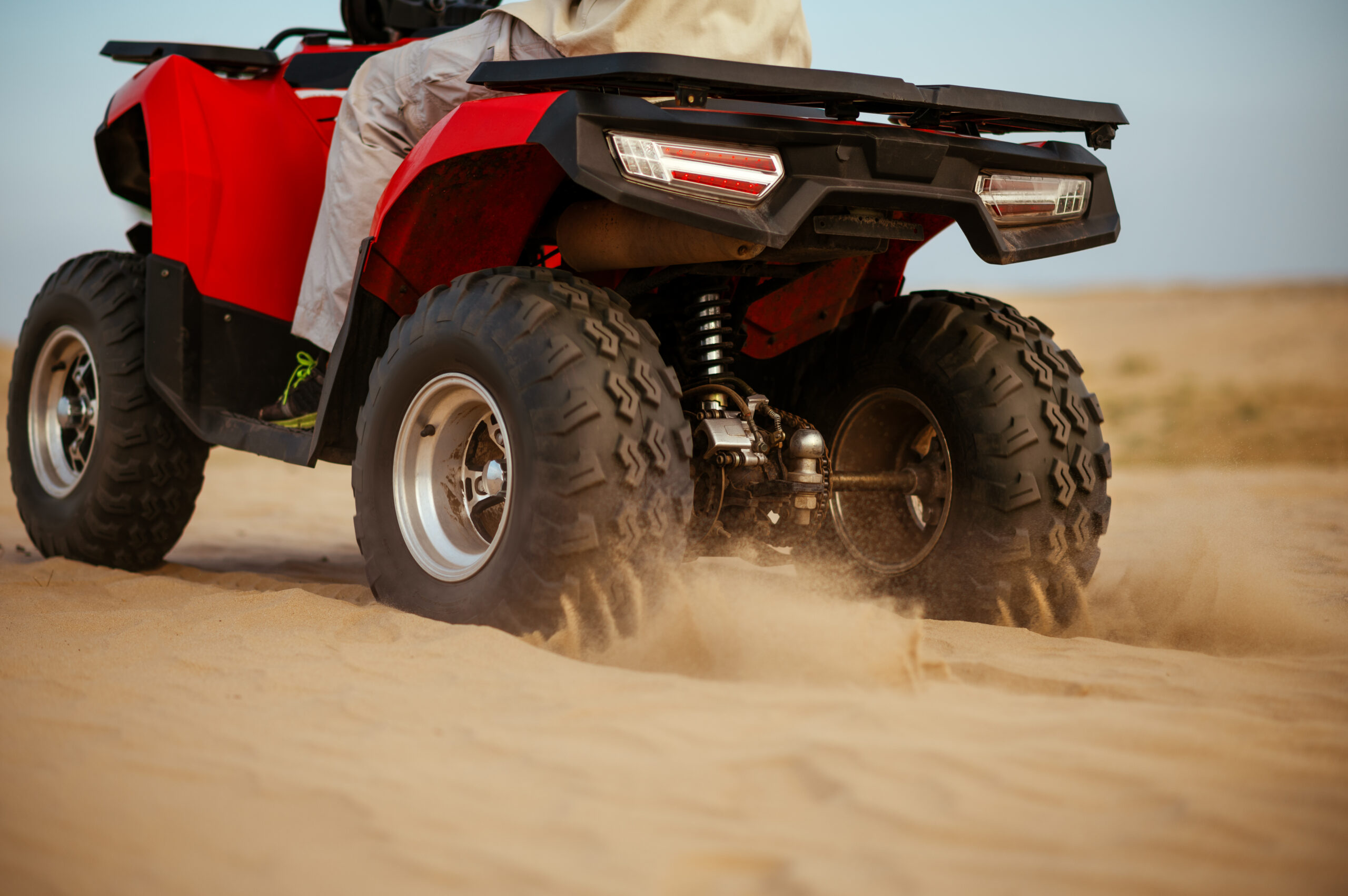 man in helmet rides on atv in desert, action view
