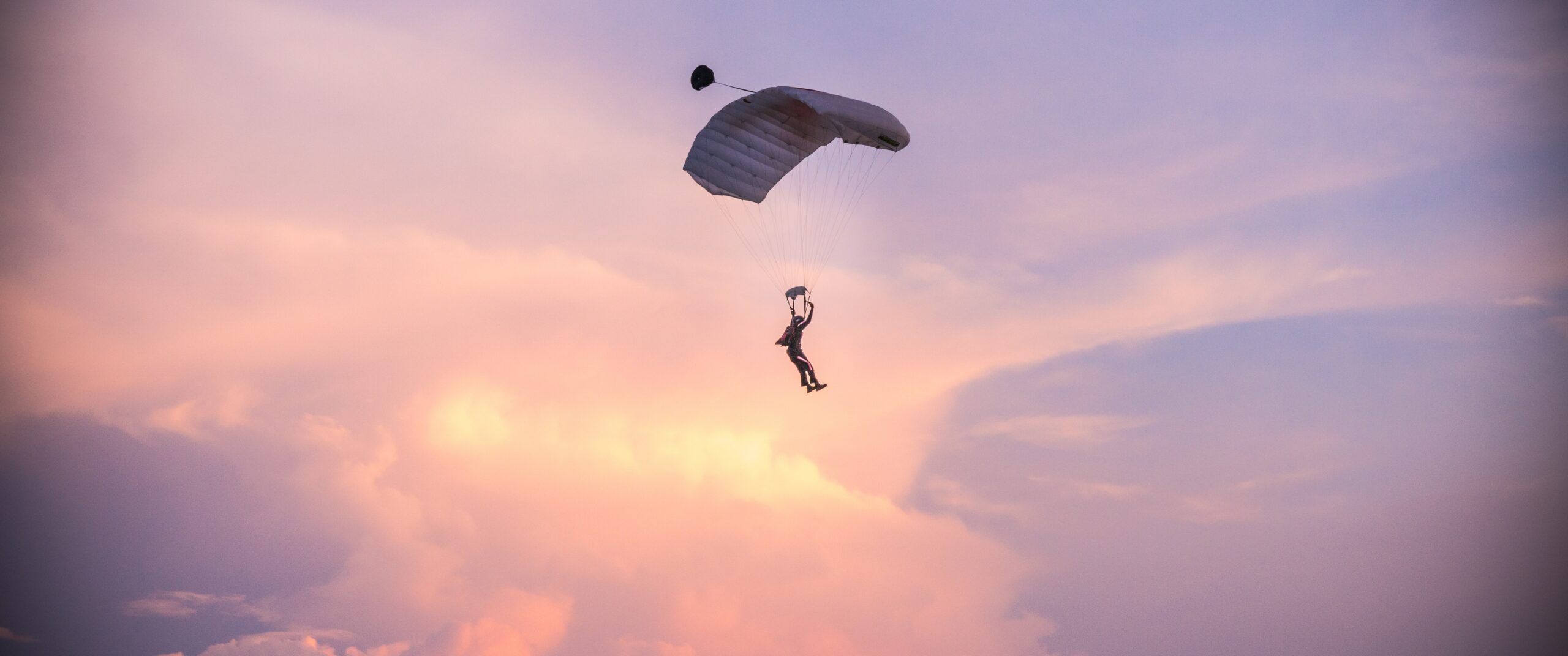skydiver silhouetted against a pink and purple sky 2026 01 05 01 13 21 utc
